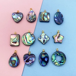 Vue détaillée de divers pendentifs en nacre d'abalone avec attaches en métal doré