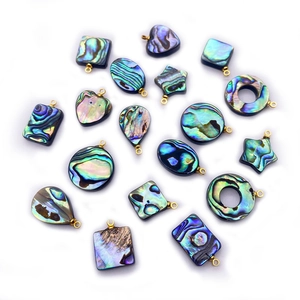Détail de pendentifs en nacre d'abalone naturelle aux formes variées avec bélières dorées