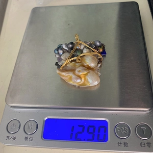 Dettaglio di un ciondolo con perla barocca fatta a mano con filo metallico, 12,9 g