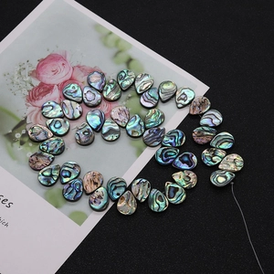 Macro detail of natural abalone shell teardrop beads with iridescent colorful texture