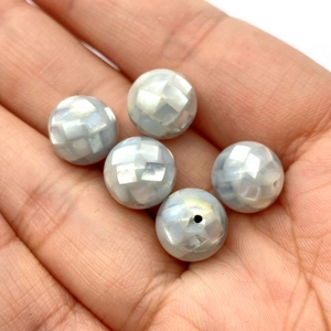 Détail macro de perles mosaïques en nacre irisées pour la création de bijoux DIY