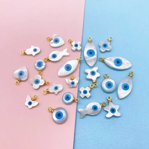 Vue macro de breloques en nacre œil grec en formes de Hamsa et cœur pour bijoux DIY