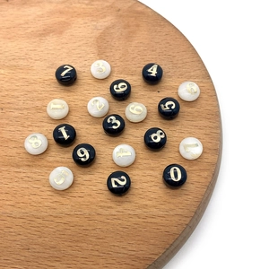 Perline di conchiglia piatte 8mm con numeri dorati su vassoio in legno per gioielli