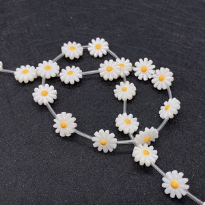 Vista macro di perle a forma di margherita bianca da 10mm per gioielli fai-da-te e accessori