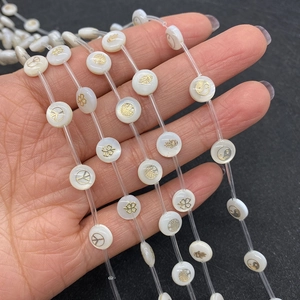 Platte ronde witte schelpkraaltjes met gouden symbolen voor DIY sieraden maken