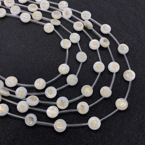 Platte ronde witte schelpkralen met gouden symbolen voor DIY sieraden maken