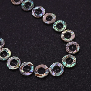 Macro shot of iridescent natural abalone shell donut beads for DIY jewelry making