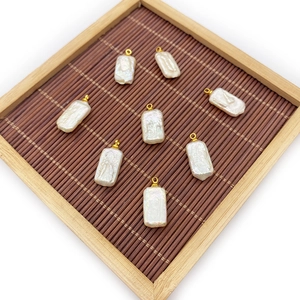 Rectangle baroque freshwater pearl pendants with gold bails on a bamboo mat