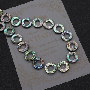 Macro shot of natural abalone shell ring beads with iridescent rainbow luster for DIY jewelry
