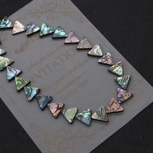 Macro detail of triangle abalone shell beads showing natural colorful luster and texture
