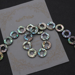 Macro shot of natural abalone shell round beads with iridescent rainbow luster for jewelry