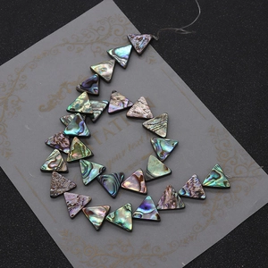 Macro detail of triangle abalone shell beads showing iridescent mother of pearl luster