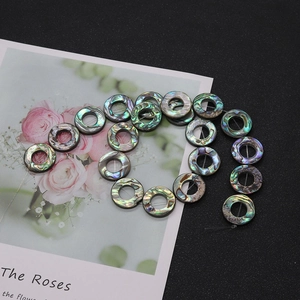 Macro shot of natural abalone shell ring beads with rainbow iridescence for DIY jewelry