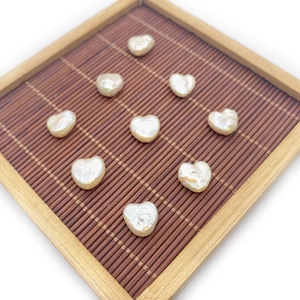 Ten pieces of heart-shaped natural freshwater baroque pearls displayed on a bamboo tray