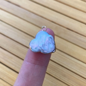 Irregular cloud-shaped natural freshwater pearl pendant with gold plating on finger