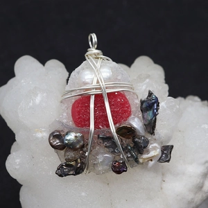 Macro shot of handmade wire wrapped heart druzy pendant with natural pearls decoration
