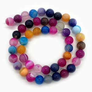 Polished natural striped agate beads in mixed colors arranged in a circle on white background