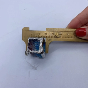 Detailed view of a 20mm cube stone pendant measured with a digital caliper