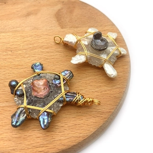 Detailed macro view of turtle pendants made from baroque pearls and natural crystals