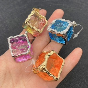 Cube crystal stone pendants with metal edges in four colors on a textured background