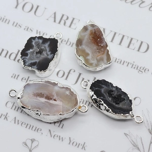 Detailed view of four irregular natural agate druzy pendants with silver plated edges