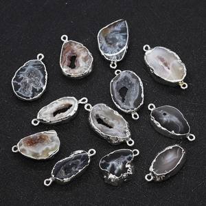 Macro detail of irregular natural agate druzy connectors with silver plated edges