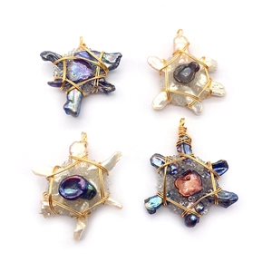 Handcrafted turtle pendants with baroque pearls and gold wire wrapping on white base