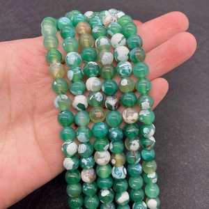 Close-up of green dragon vein agate beads with natural white patterns and polished surface