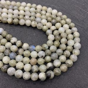 Dettaglio macro di perle tonde in labradorite naturale con riflessi blu e dorati vivaci