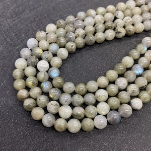 Dettaglio macro di perle tonde in labradorite naturale con vivace iridescenza blu e gialla