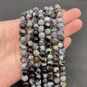 Detalle de cuentas de piedra natural veteada azul y negra para la creación de joyas DIY