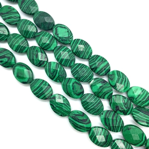 Macro shot of malachite faceted oval beads showing green wavy patterns for DIY jewelry