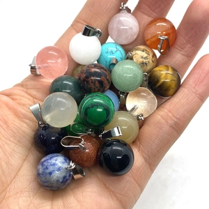 Pendentifs sphères en cristal de 14mm avec attaches argentées tenus en main