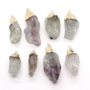A set of irregular natural stone pendants with gold plated metal tops on white background