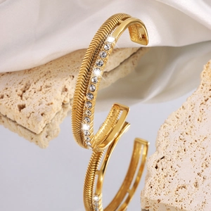 Detailed close-up of a double-layered gold titanium bracelet with crystals and textures