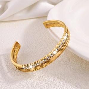 Titanium steel open bangle with herringbone texture and central row of clear zircons