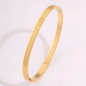 Detailed close-up of golden stainless steel slim bangle with classic Greek Key pattern