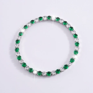 Macro de una pulsera de acero de titanio con piedras alternas de color verde esmeralda y blanco