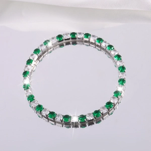 Detalle del brazalete de acero de titanio con alternancia de gemas verdes y circonitas