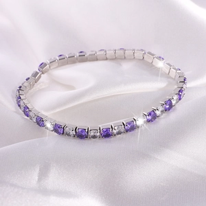 Detalle de la pulsera tenis plateada con circonitas brillantes en color púrpura y blanco