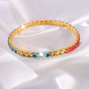 Primer plano de pulsera de acero de titanio con cristales de arcoiris sobre seda