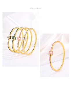 Detail of luxury gold titanium bangle featuring colorful crystals and a twist design