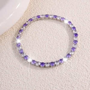 Primer plano de pulsera de tenis con circonitas alternas en tonos púrpura y blanco