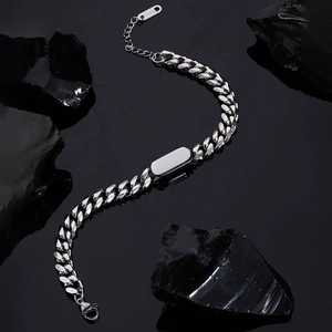 Detailansicht eines silbernen Panzerarmbands mit gravierbarem Steg auf schwarzem Stein
