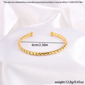 Vista detallada de la textura de cuerda retorcida y el diámetro de 6 cm del brazalete dorado