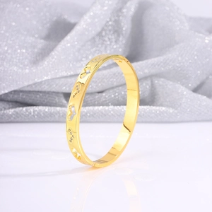Detailed macro view of heart hollow-out design and fine zircon stones on golden steel bangle