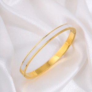 Detailopname van 18k vergulde roestvrijstalen armband met wit emaille inlegwerk design