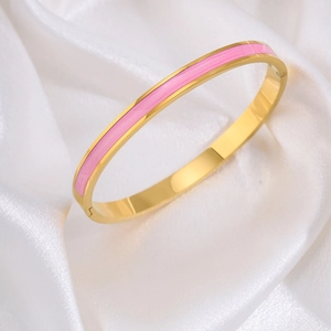 Detailopname van een 18k vergulde armband met roze emaille op zachte witte zijden stof