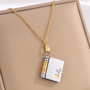 Golden book-shaped pendant necklace with heart detail on premium jewelry box display