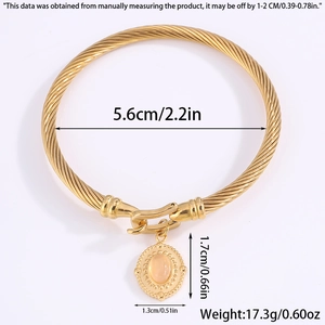 Detailed view of golden twisted cable bracelet with a pink stone oval pendant and sizing info